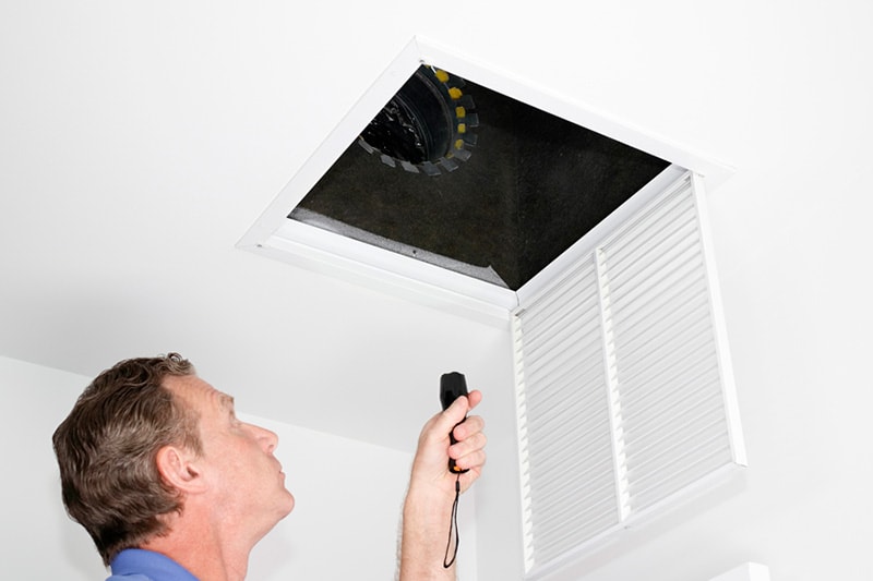 Man Inspecting Sound From HVAC